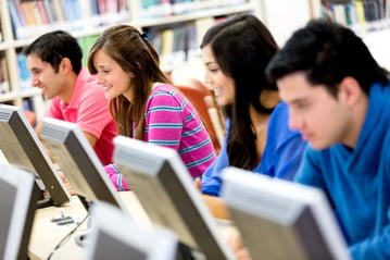 Group of young people studying at the library using computers.jpeg